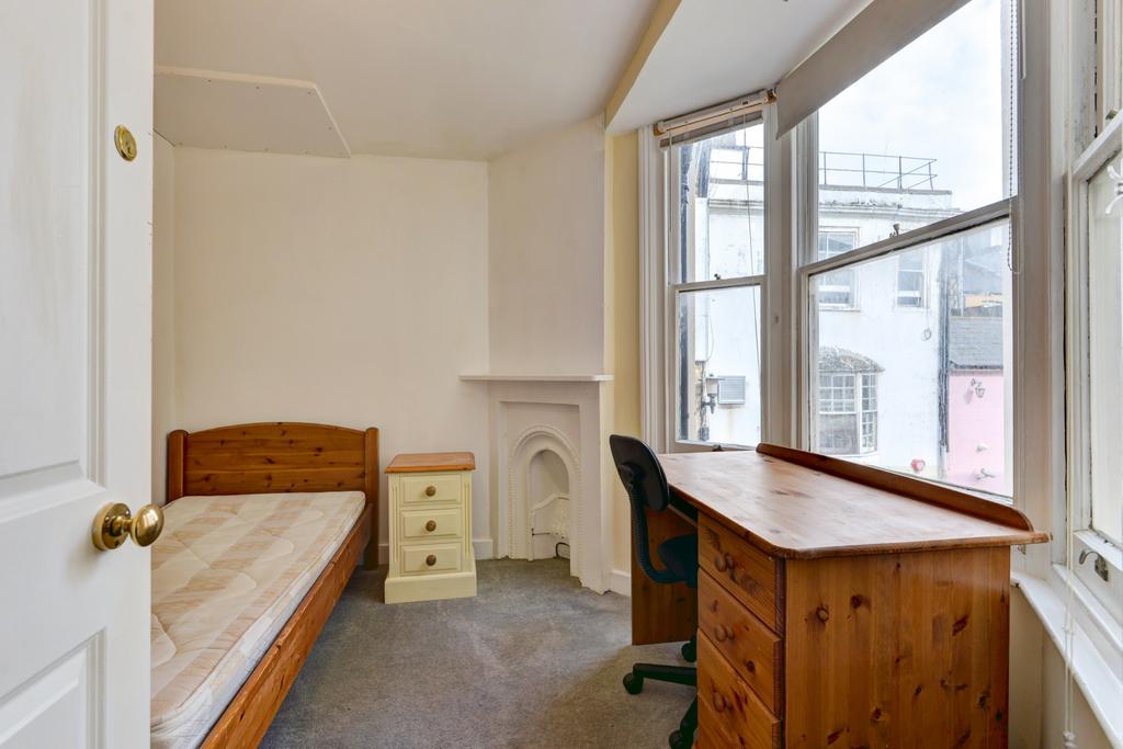 A cozy bedroom with a wooden single bed and a l...