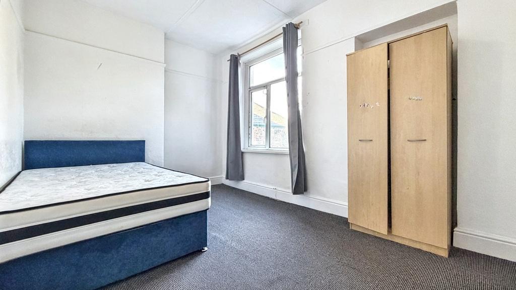Bright, simply furnished bedroom with a comfort...