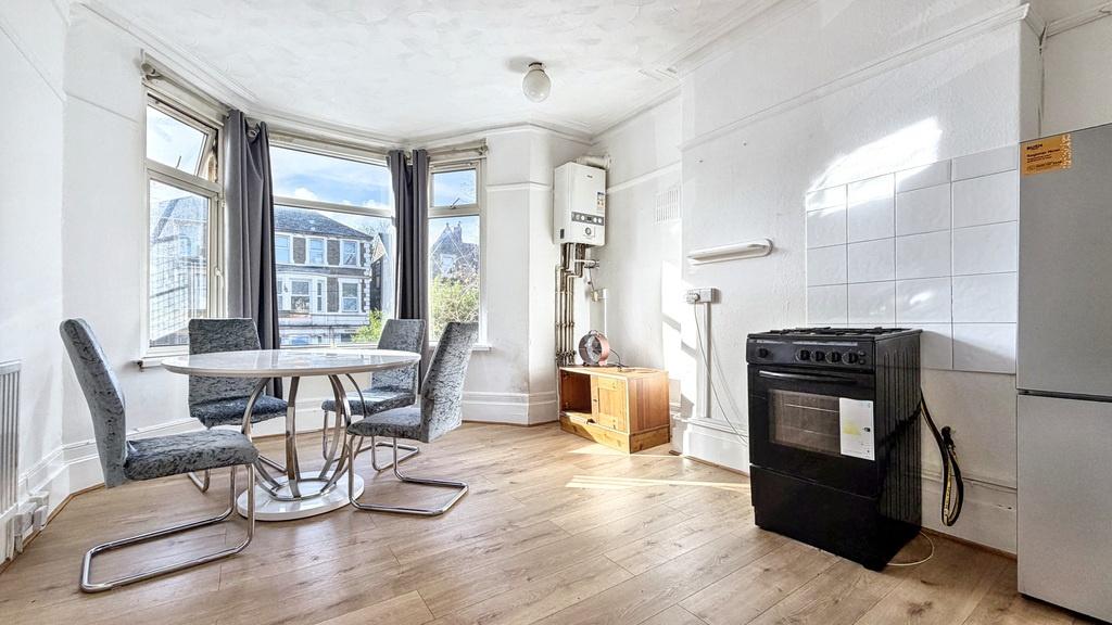 Bright kitchen/dining area with a bay window, w...
