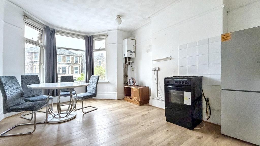 Bright open-plan living area with a bay window,...