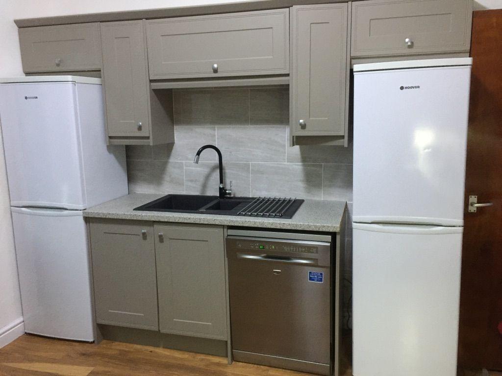 Neat modern kitchen with matching shaker cabine...