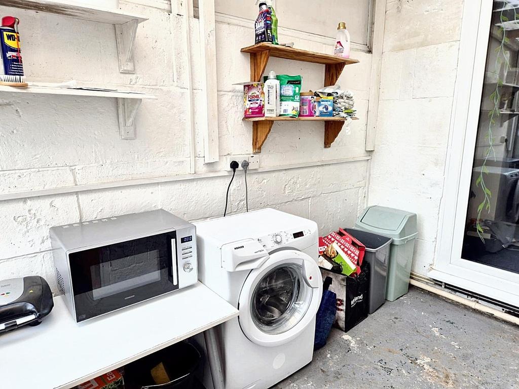 Bright utility area with a washing machine, mic...