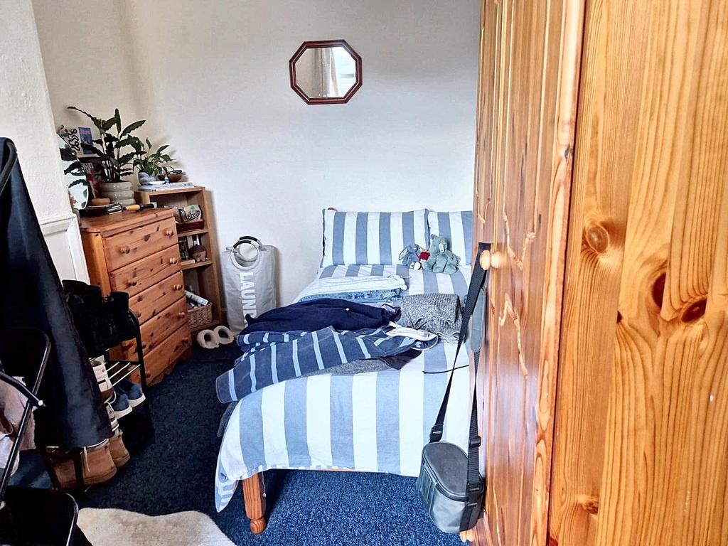 Cozy single bedroom with striped daybed, wooden...