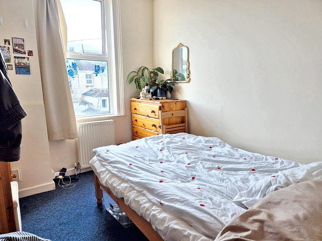 Bright, simply furnished bedroom with a comfort...