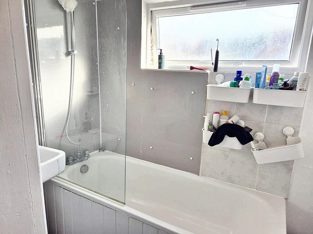 Bright modern bathroom with a bathtub and overh...