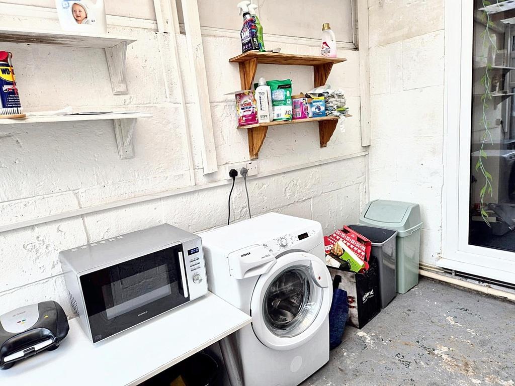 Utility area with a washing machine, microwave ...