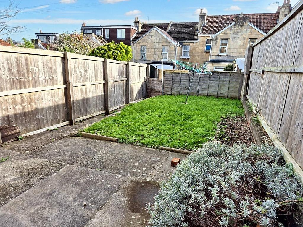 Enclosed rear garden with a paved patio leading...