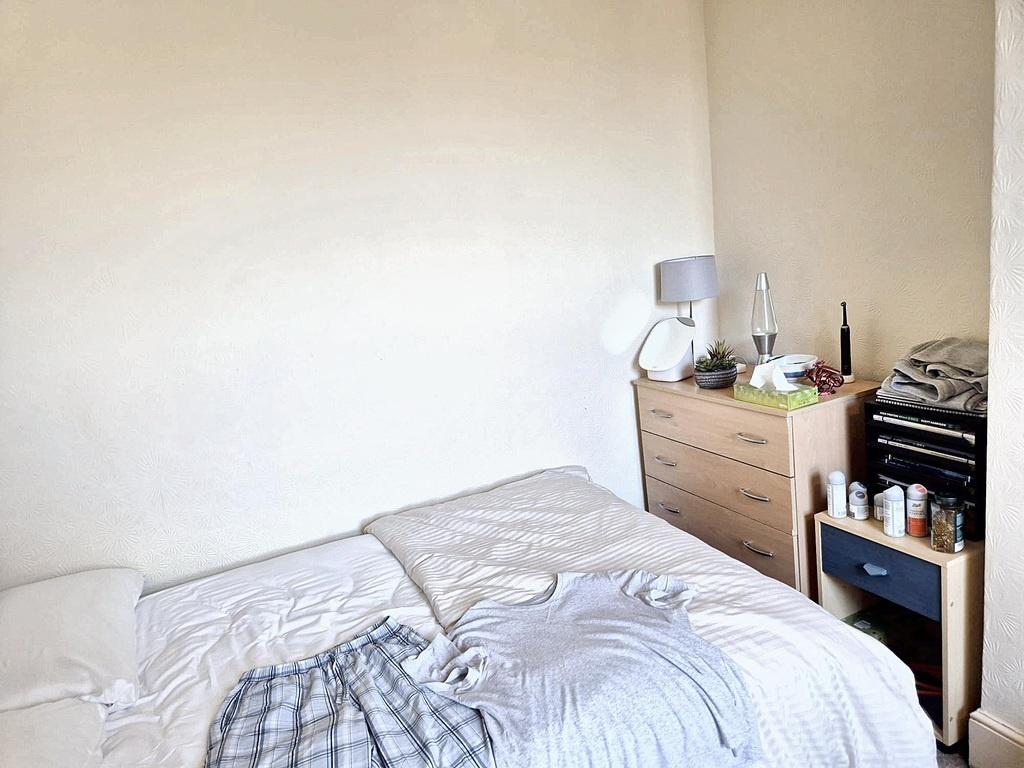 Bright, simply furnished bedroom with a double ...