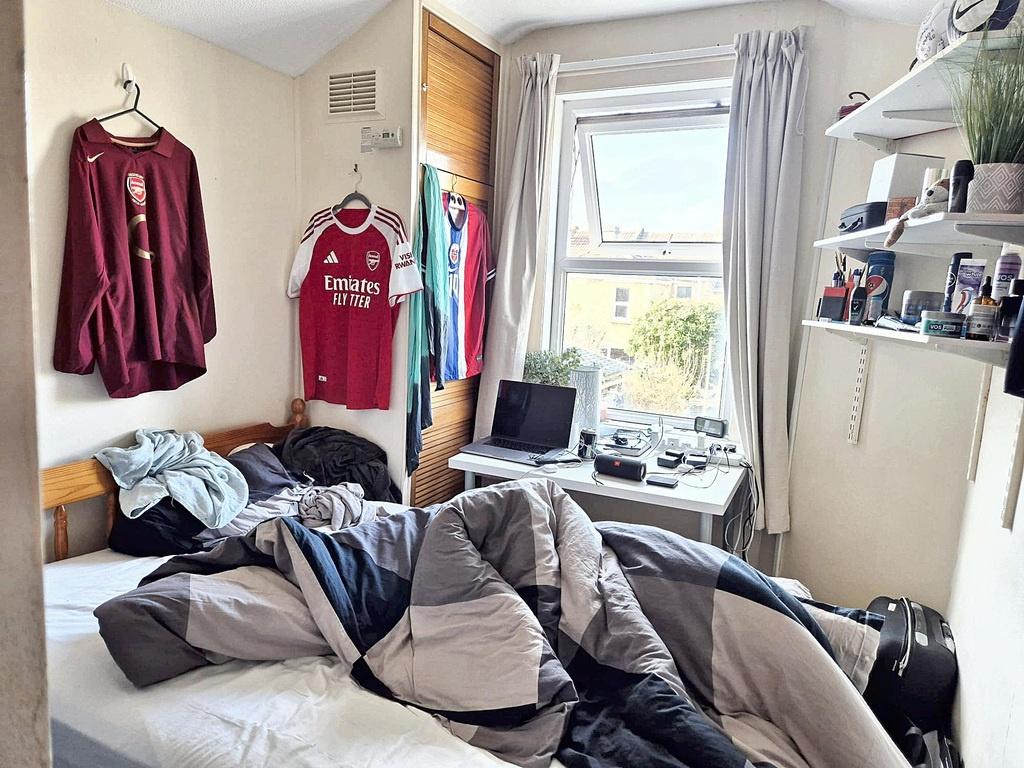 Bright single bedroom with a large window bring...