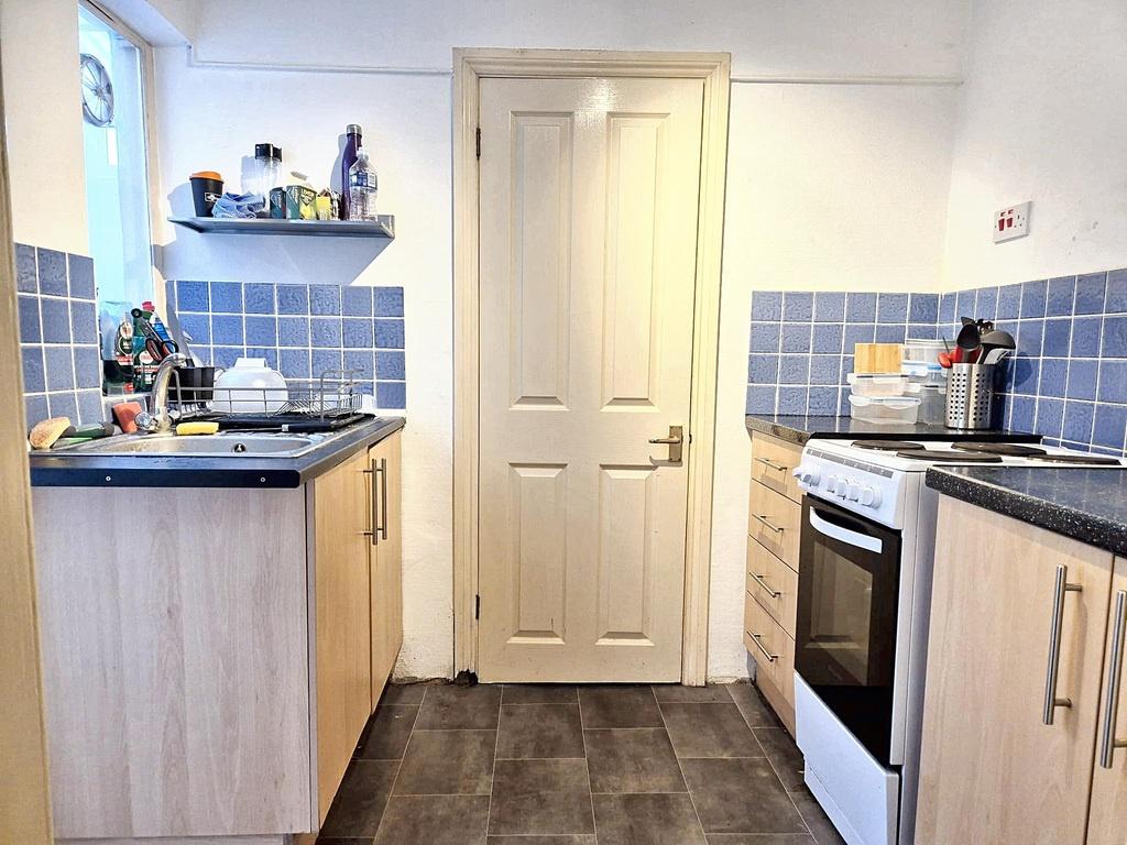 Bright compact kitchen with light wood cabinets...