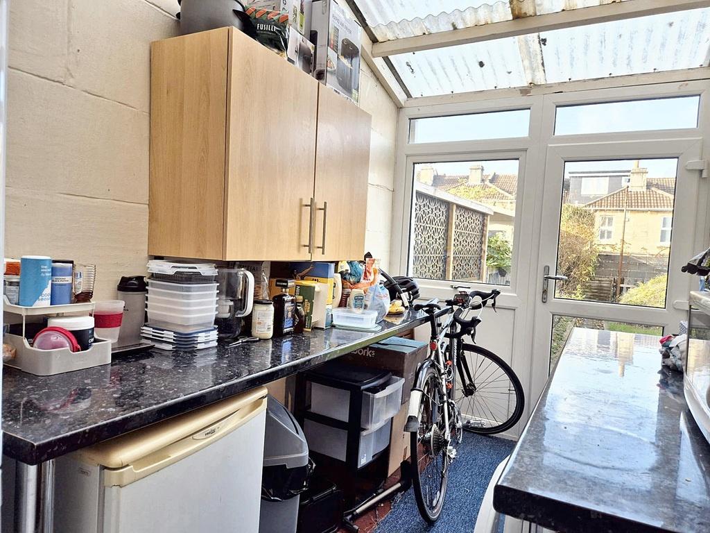 Bright galley-style kitchen with light wood cab...