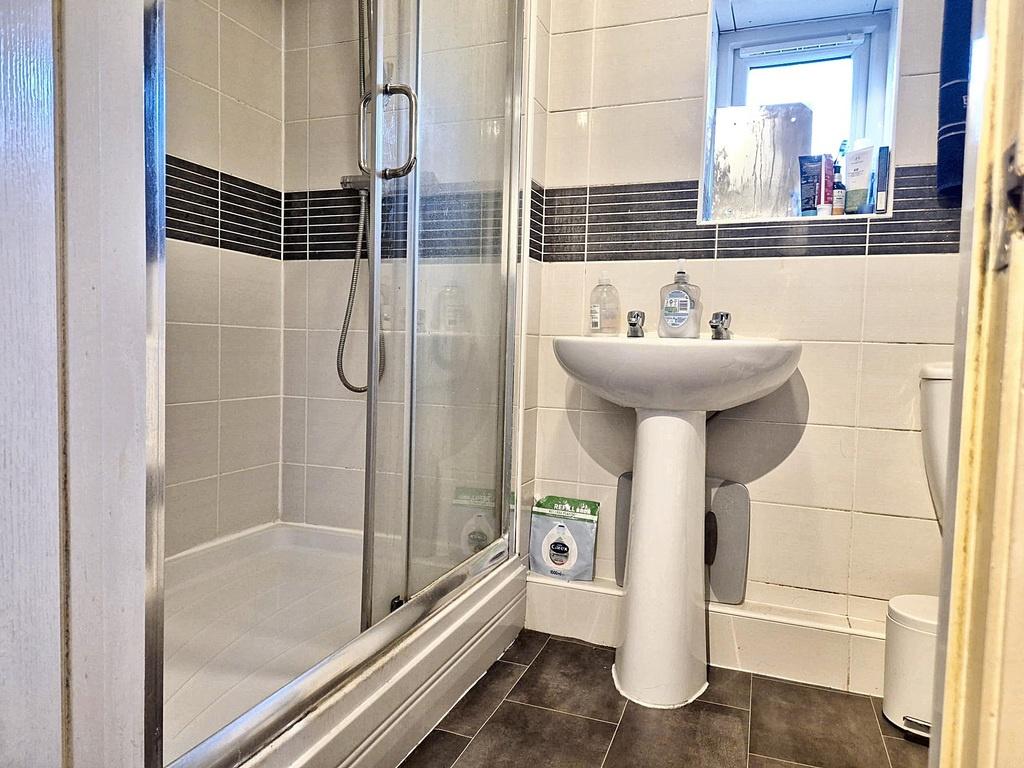 Clean modern bathroom with a glass-enclosed sho...