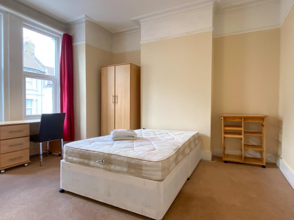 A spacious double bedroom featuring a comfortab...