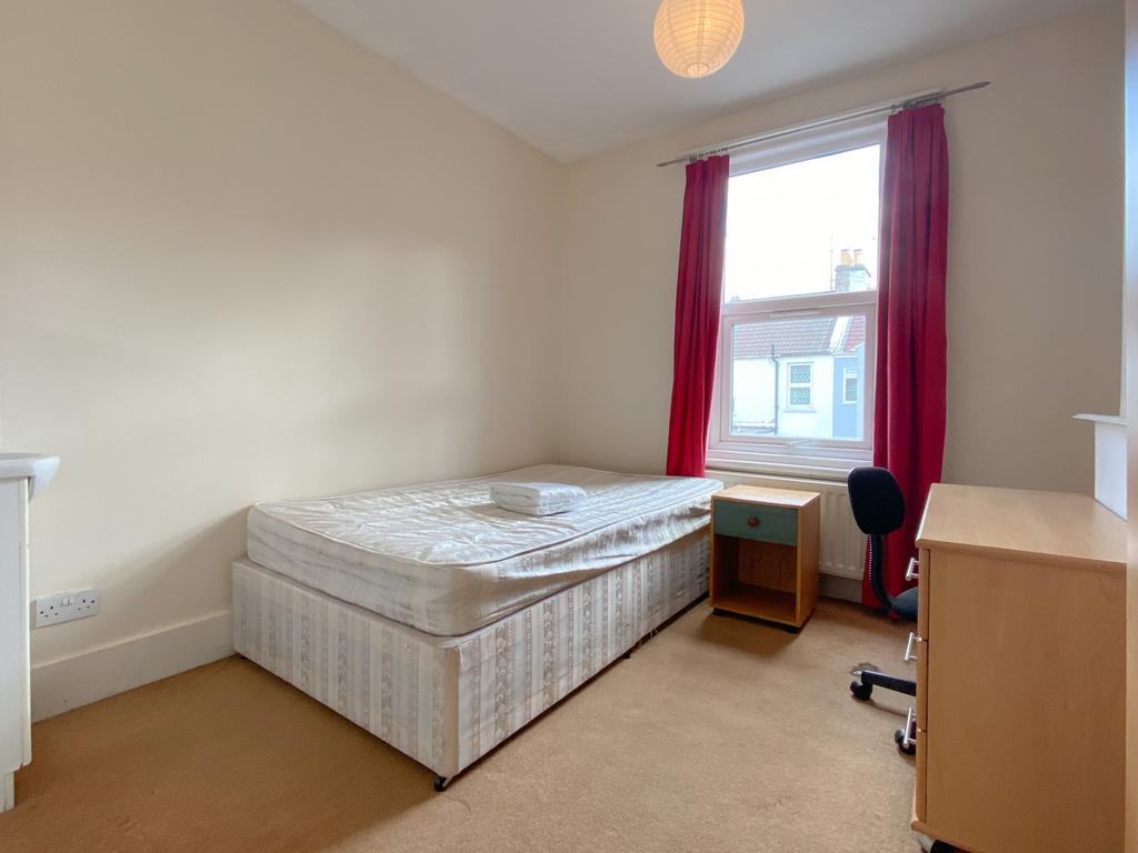 A tidy, well-lit single bedroom featuring a com...