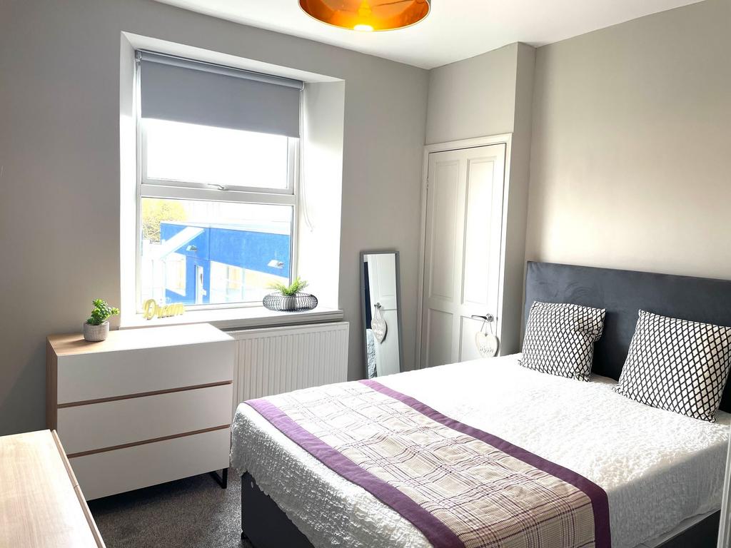 Bright and modern master bedroom featuring a la...