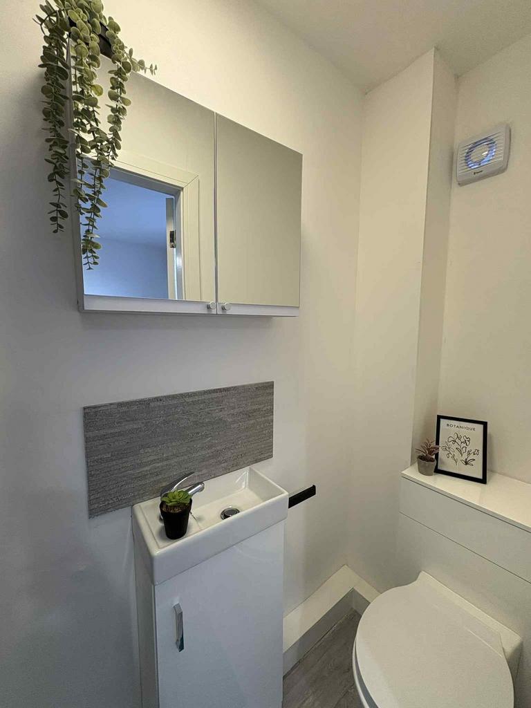 Compact, modern bathroom with a vanity basin, m...