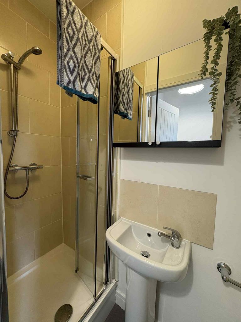 Bright, modern bathroom with a tiled shower enc...