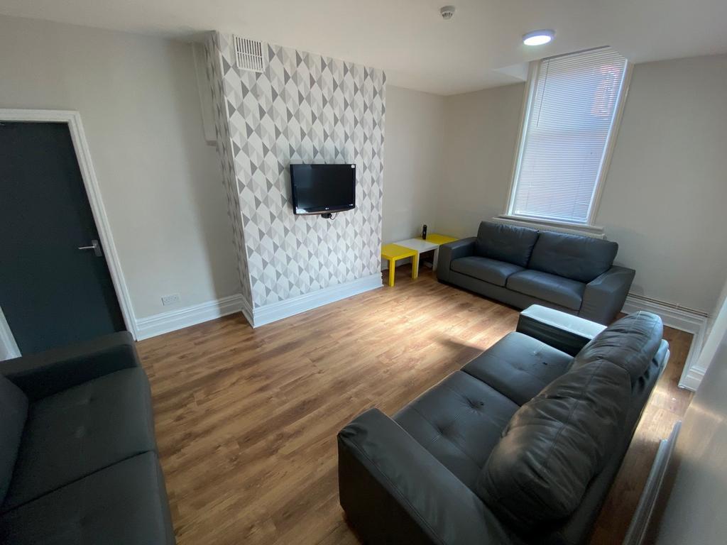 A stylish and spacious living room with ample n...