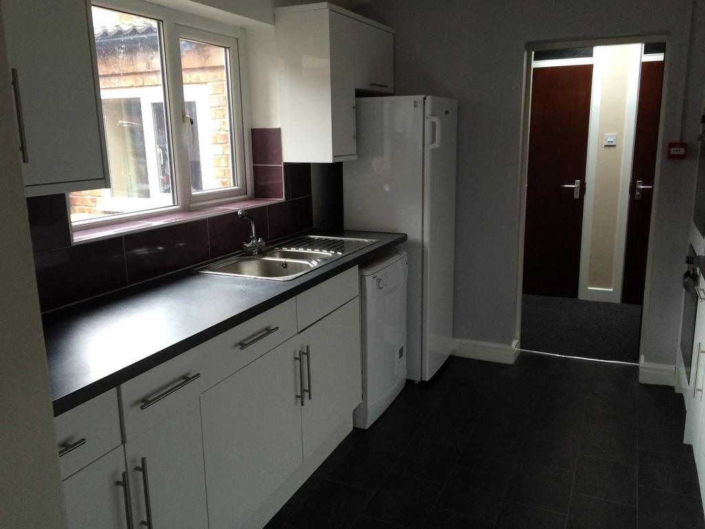 A modern and tidy kitchenette with ample storag...