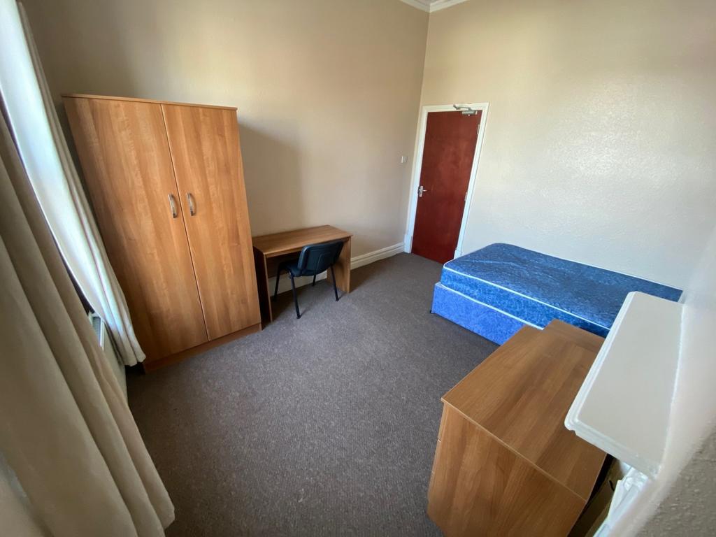 A tidy and inviting single bedroom featuring a ...