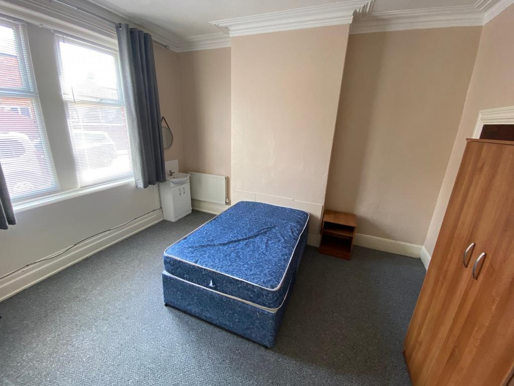 A spacious and well-lit double bedroom with mod...