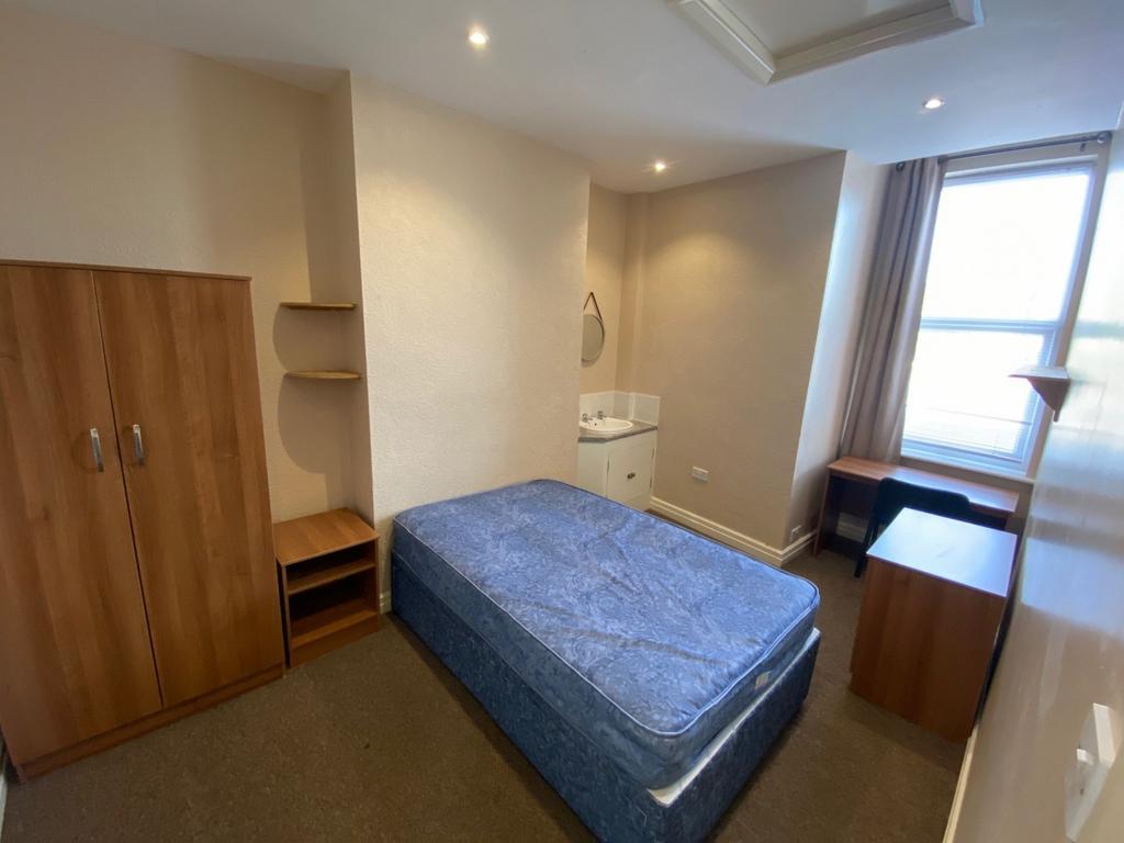 A spacious and well-lit double bedroom with ess...