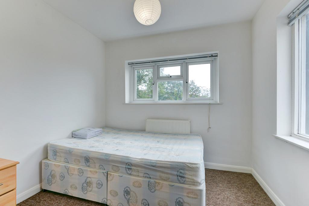 A clean, well-lit small bedroom featuring a sin...