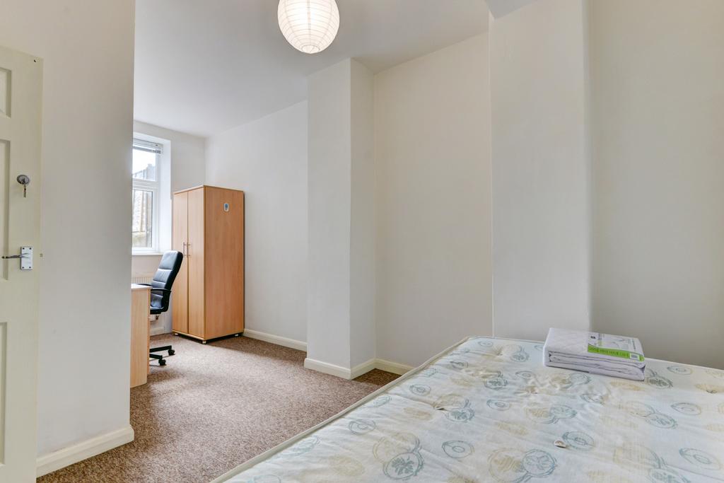 A bright and tidy bedroom featuring a single be...