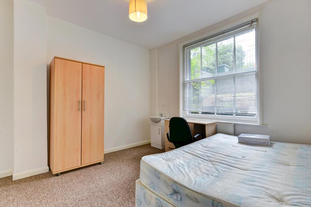 A bright and tidy single bedroom with a large w...