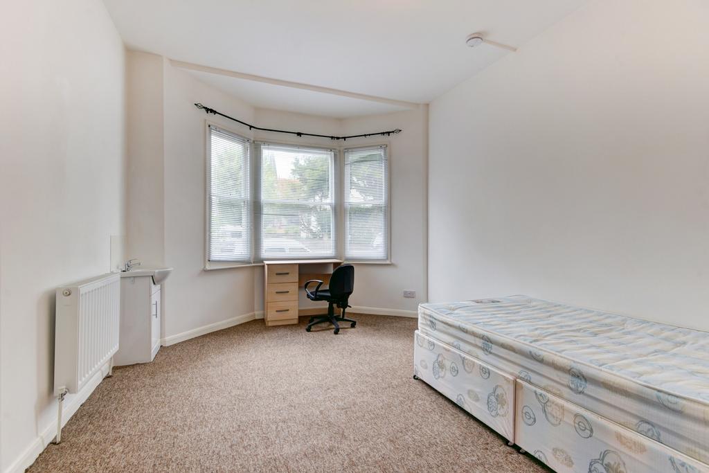 A bright and spacious bedroom featuring a large...