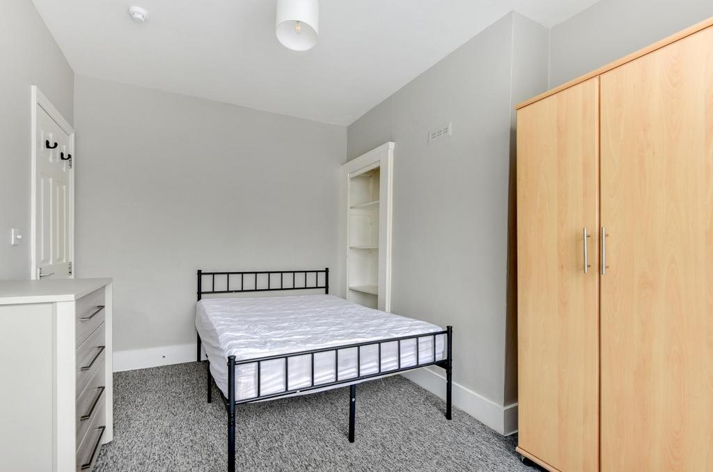 A well-lit double bedroom featuring a sturdy do...