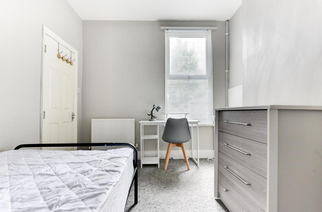 A bright and airy bedroom featuring a tidy spac...