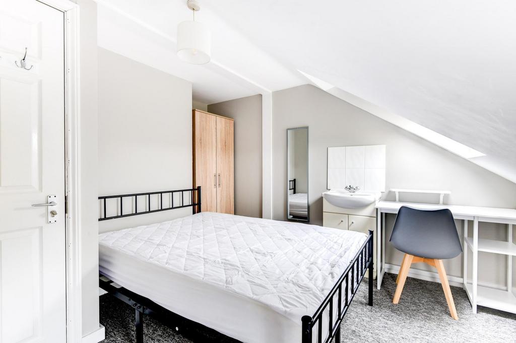 A bright and well-maintained bedroom featuring ...