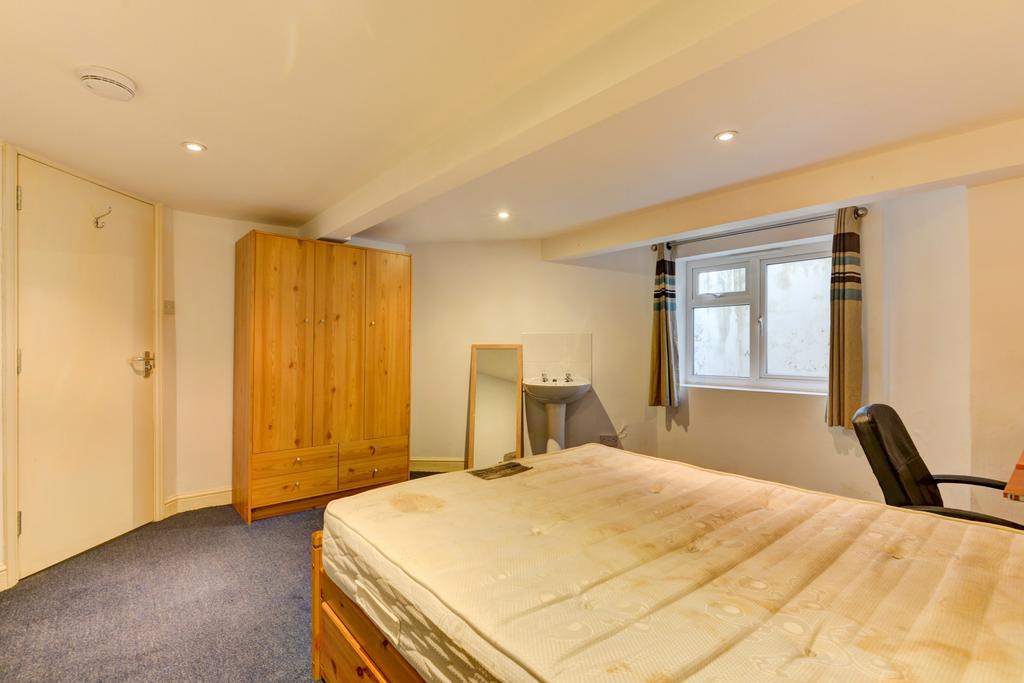 A cozy bedroom featuring a double bed, a window...