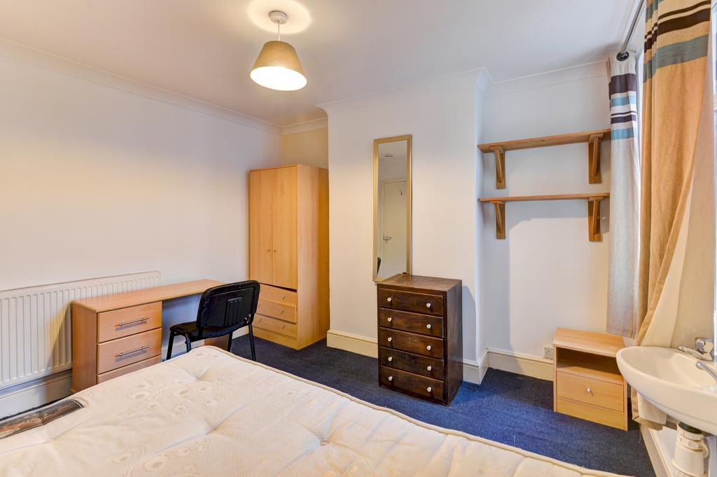 A cozy bedroom featuring a bed, wardrobe, and a...