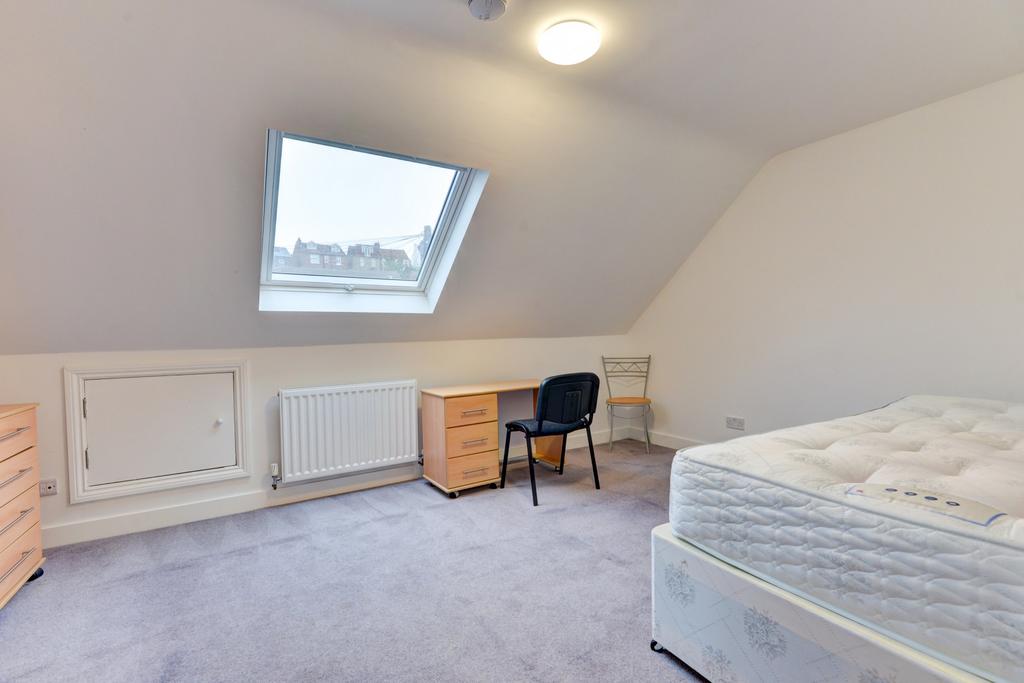 A bright and tidy bedroom with a large skylight...