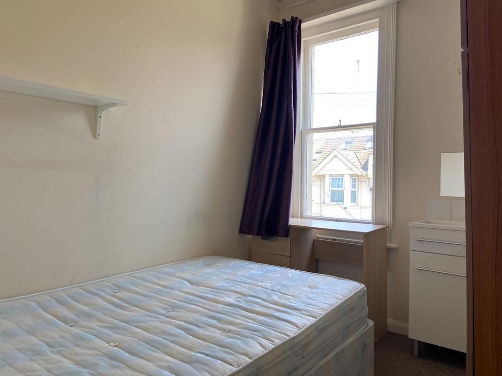 A well-maintained bedroom with a large window a...