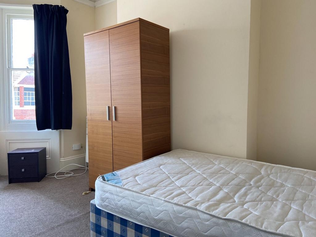 A tidy bedroom featuring a comfortable bed, a w...