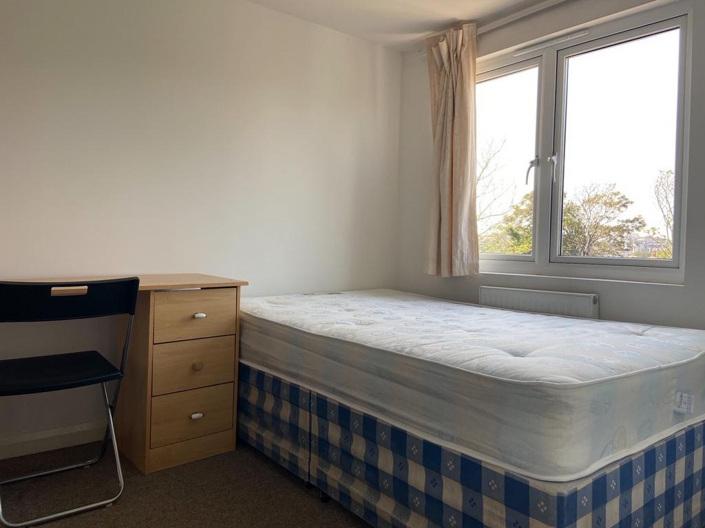 A tidy and well-lit bedroom with a comfortable ...