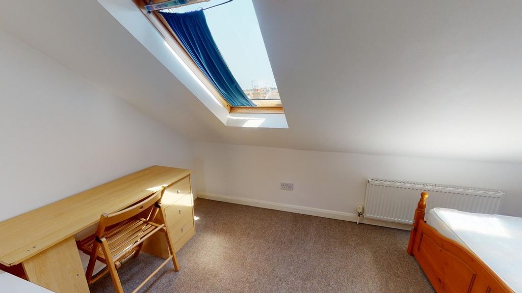 A cozy bedroom with a skylight providing natura...