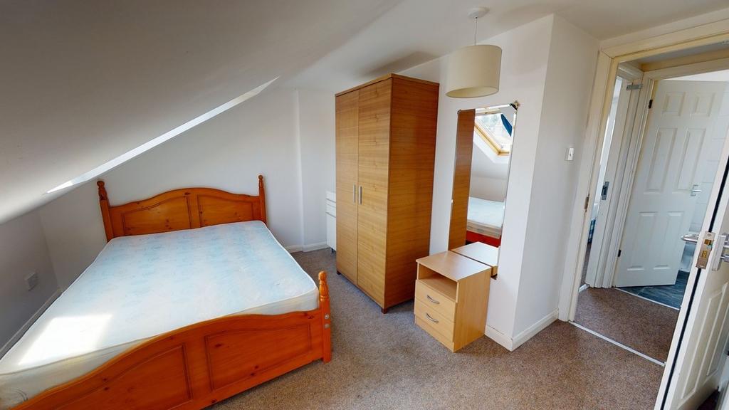A cozy bedroom featuring a double bed with a wo...