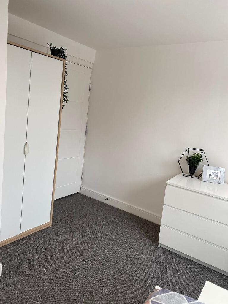 Bright, simply styled bedroom corner with neutr...
