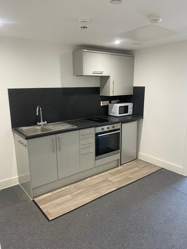 A modern and tidy kitchenette featuring sleek c...