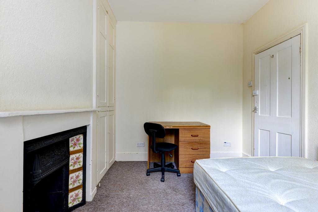 A well-maintained bedroom featuring a bed and a...