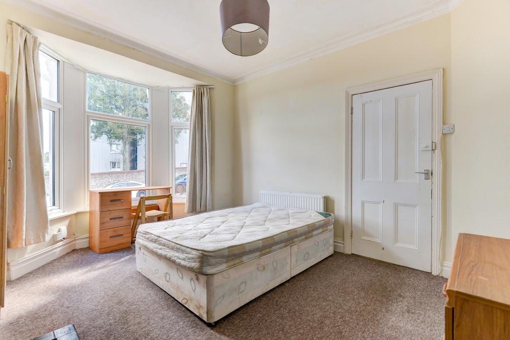 A well-lit bedroom featuring a free-standing ma...