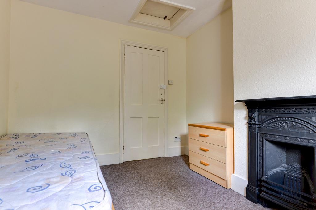 A well-maintained bedroom featuring a bed, a wo...