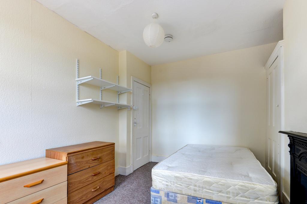 A spacious double bedroom with a comfortable be...