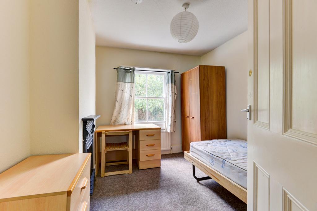 A tidy and well-lit bedroom featuring a single ...