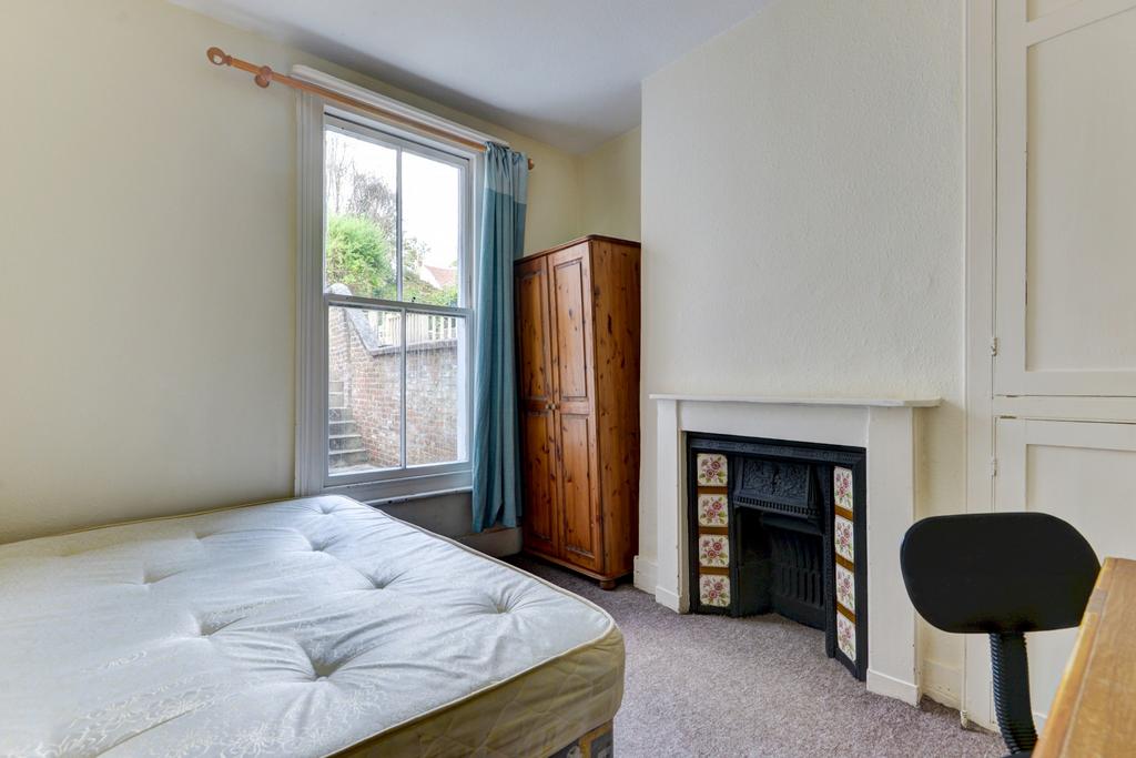 A spacious master bedroom featuring a large win...