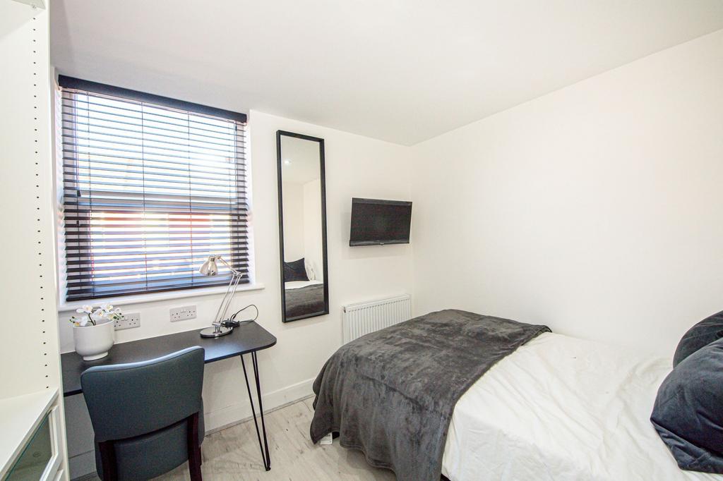 A modern, well-lit bedroom featuring a comforta...